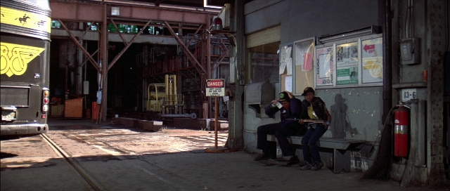 Wide shot frame from The Adventures of Buckaroo Banzai Across the 8th Dimension — sitting, dialogue, fire