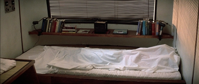Frame from The Adventures of Buckaroo Banzai Across the 8th Dimension — book, room, bed