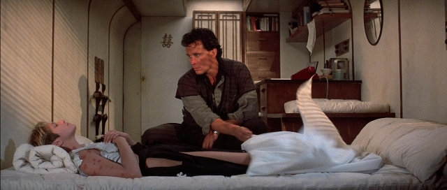 Wide shot frame from The Adventures of Buckaroo Banzai Across the 8th Dimension — sitting, room, bed
