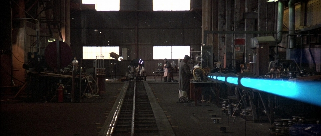 Wide shot frame from The Adventures of Buckaroo Banzai Across the 8th Dimension — standing, train, pipe