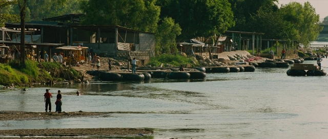 Wide shot frame from Sin nombre — standing, water, person