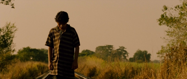Wide shot frame from Sin nombre — standing, shirt, face