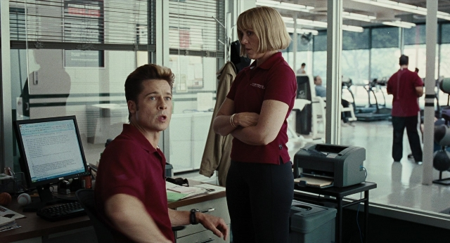Wide shot frame from Burn After Reading — sitting, desk, standing