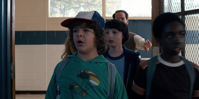 Wide shot frame from Stranger Things — standing, hat, shirt