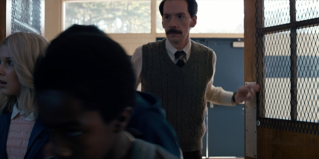 Wide shot frame from Stranger Things — standing, room, dialogue