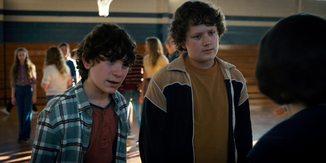 Wide shot frame from Stranger Things — sitting, standing, walking