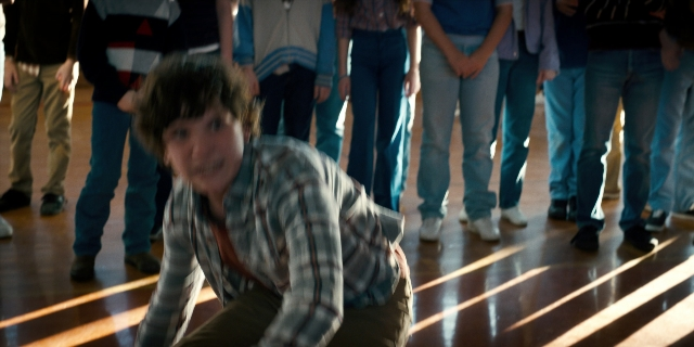 Wide shot frame from Stranger Things — standing, room, shirt