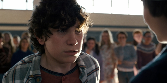 Wide shot frame from Stranger Things — standing, room, shirt