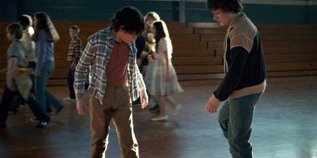 Wide shot frame from Stranger Things — standing, walking, room
