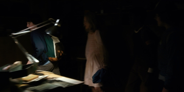Wide shot frame from Stranger Things — standing, room, dress