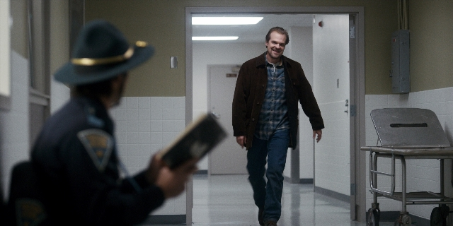Wide shot frame from Stranger Things — standing, walking, door