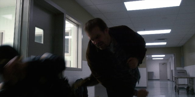 Wide shot frame from Stranger Things — room, hand, fight