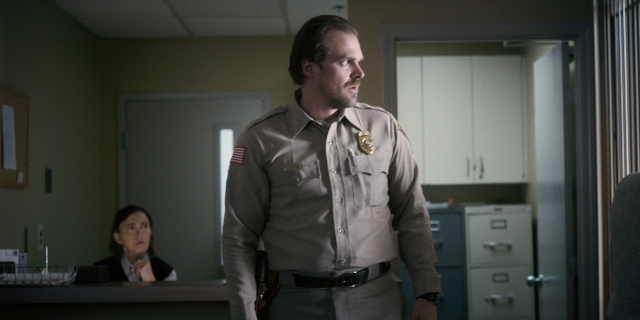 Wide shot frame from Stranger Things — sitting, standing, uniform