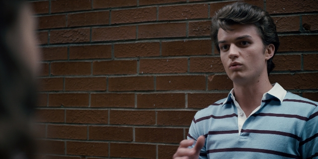 Wide shot frame from Stranger Things — standing, room, hand
