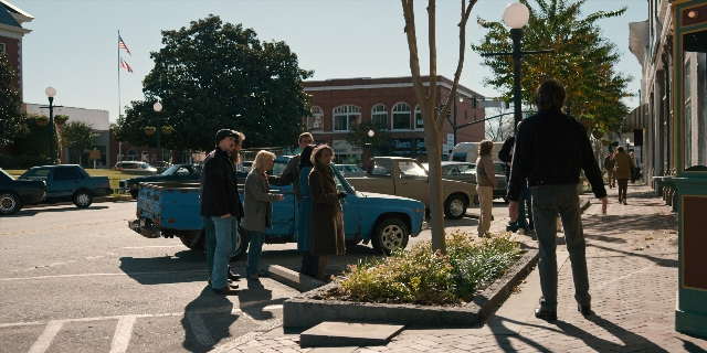 Wide shot frame from Stranger Things — standing, dialogue, street