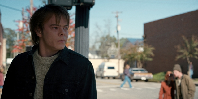 Wide shot frame from Stranger Things — standing, walking, street