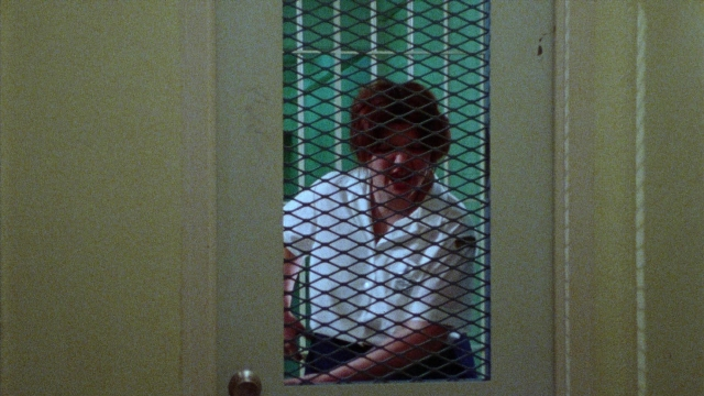 Frame from Female Trouble — sitting, door, shirt