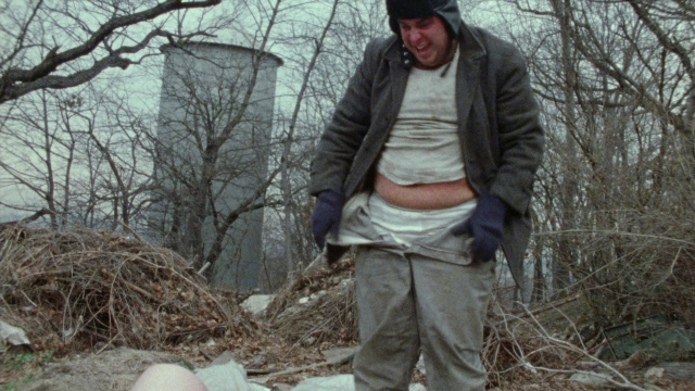 Medium shot frame from Female Trouble — standing, shirt, jacket