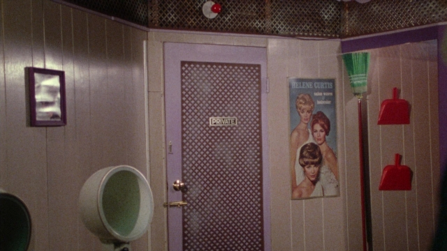 Wide shot frame from Female Trouble — door, bathroom, hair