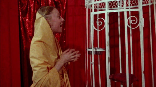 Wide shot frame from Female Trouble — standing, room, dialogue