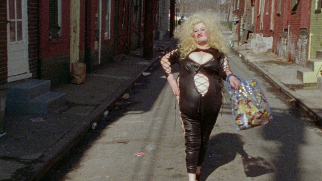 Wide shot frame from Female Trouble — walking, street, hand