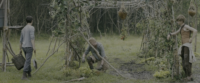 Wide shot frame from The Maze Runner — standing, bed, shirt