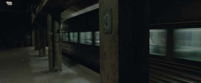 Wide shot frame from The Matrix — train, window, building