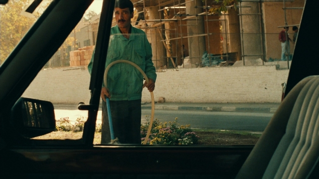 Wide shot frame from Ta'm e guilass — standing, street, car