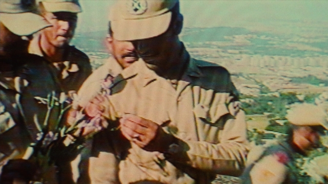 Frame from Ta'm e guilass — standing, hat, uniform