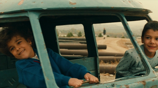 Wide shot frame from Ta'm e guilass — sitting, street, person
