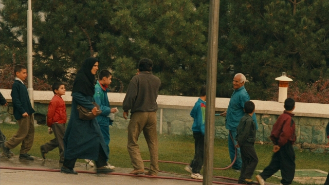 Wide shot frame from Ta'm e guilass — walking, street, bag