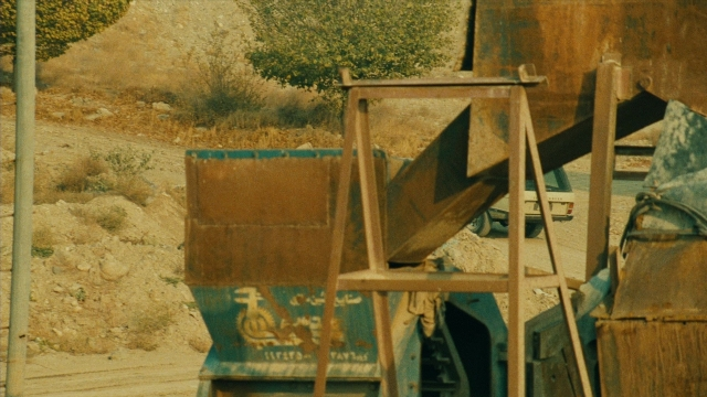 Wide shot frame from Ta'm e guilass — street, wheel, land vehicle