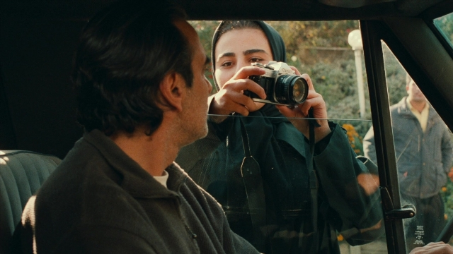 Wide shot frame from Ta'm e guilass — sitting, street, car