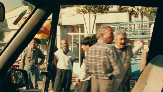 Wide shot frame from Ta'm e guilass — standing, walking, dialogue