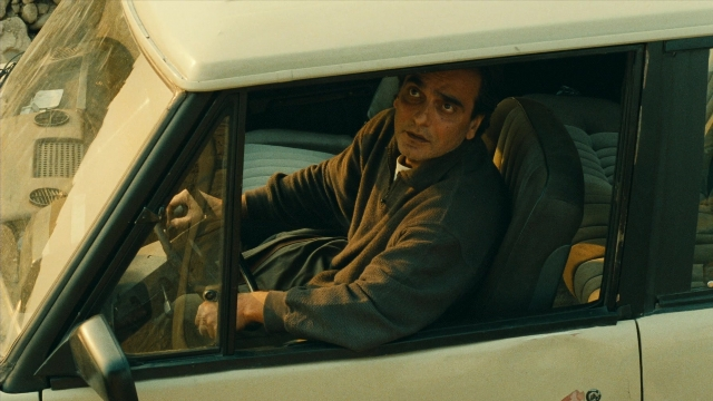 Wide shot frame from Ta'm e guilass — sitting, car, face