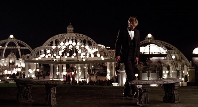 Wide shot frame from Meet Joe Black — walking, table, hand