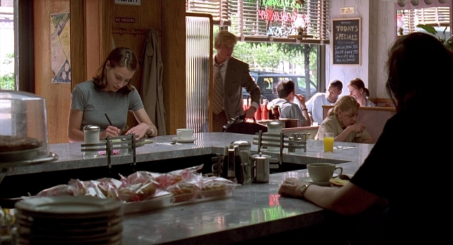 Wide shot frame from Meet Joe Black — sitting, standing, table