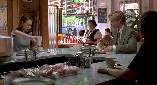 Wide shot frame from Meet Joe Black — sitting, standing, table