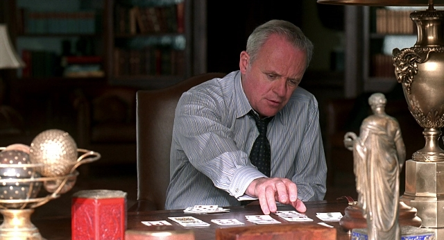 Wide shot frame from Meet Joe Black — sitting, table, hand