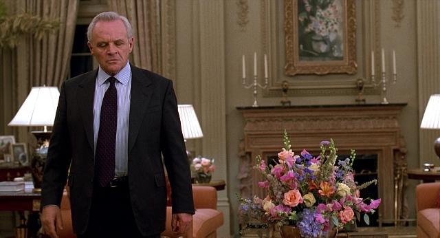 Wide shot frame from Meet Joe Black — walking, room, table
