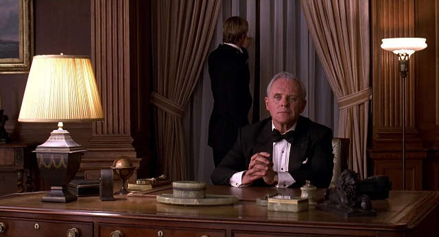 Wide shot frame from Meet Joe Black — sitting, desk, room
