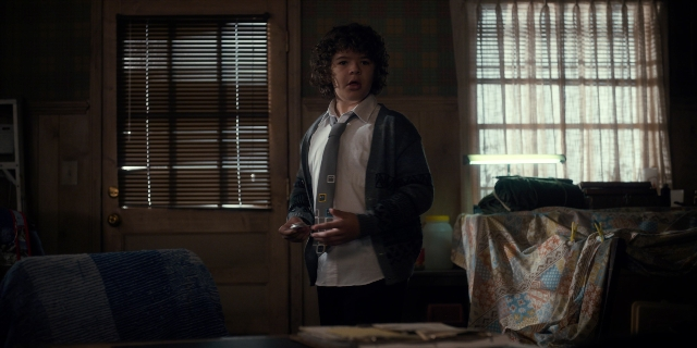 Wide shot frame from Stranger Things — standing, room, hand