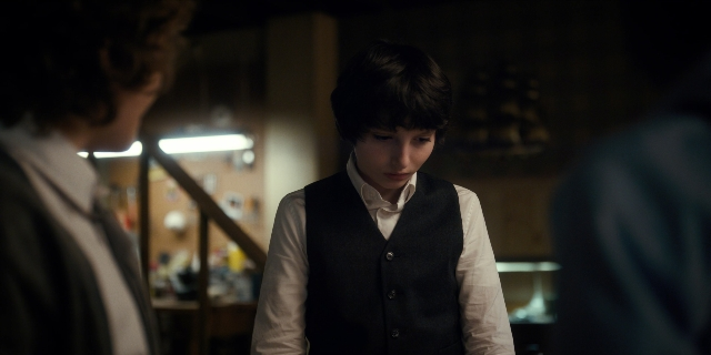 Wide shot frame from Stranger Things — standing, room, dialogue