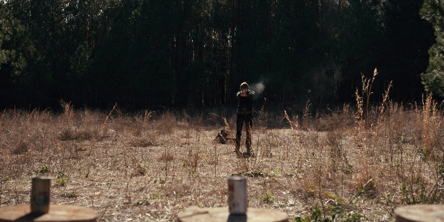 Wide shot frame from Stranger Things — standing, hand, gun