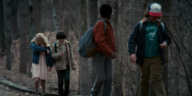 Wide shot frame from Stranger Things — walking, dress, shirt
