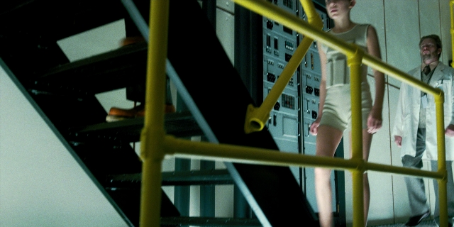 Wide shot frame from Stranger Things — standing, room, suit