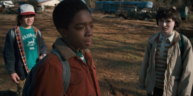 Medium shot frame from Stranger Things — standing, hat, shirt