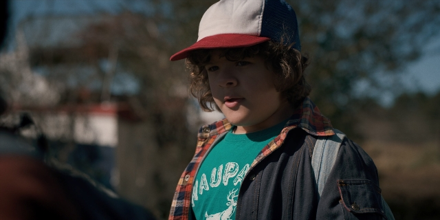 Wide shot frame from Stranger Things — standing, hat, shirt