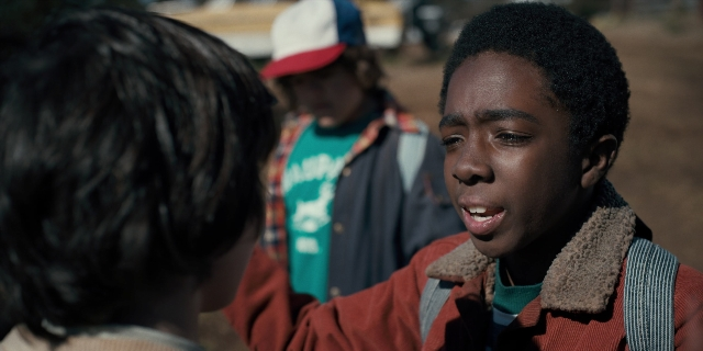 Medium shot frame from Stranger Things — standing, hat, shirt