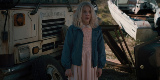 Wide shot frame from Stranger Things — standing, dress, face